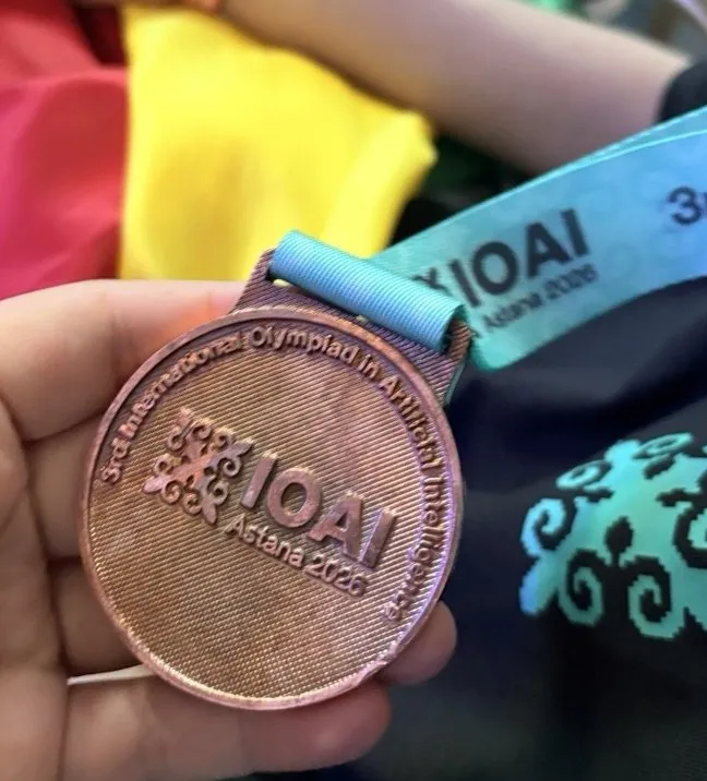 Primer plano de la medalla de bronce de la tercera Olimpiada Internacional de IA, Astana 2026